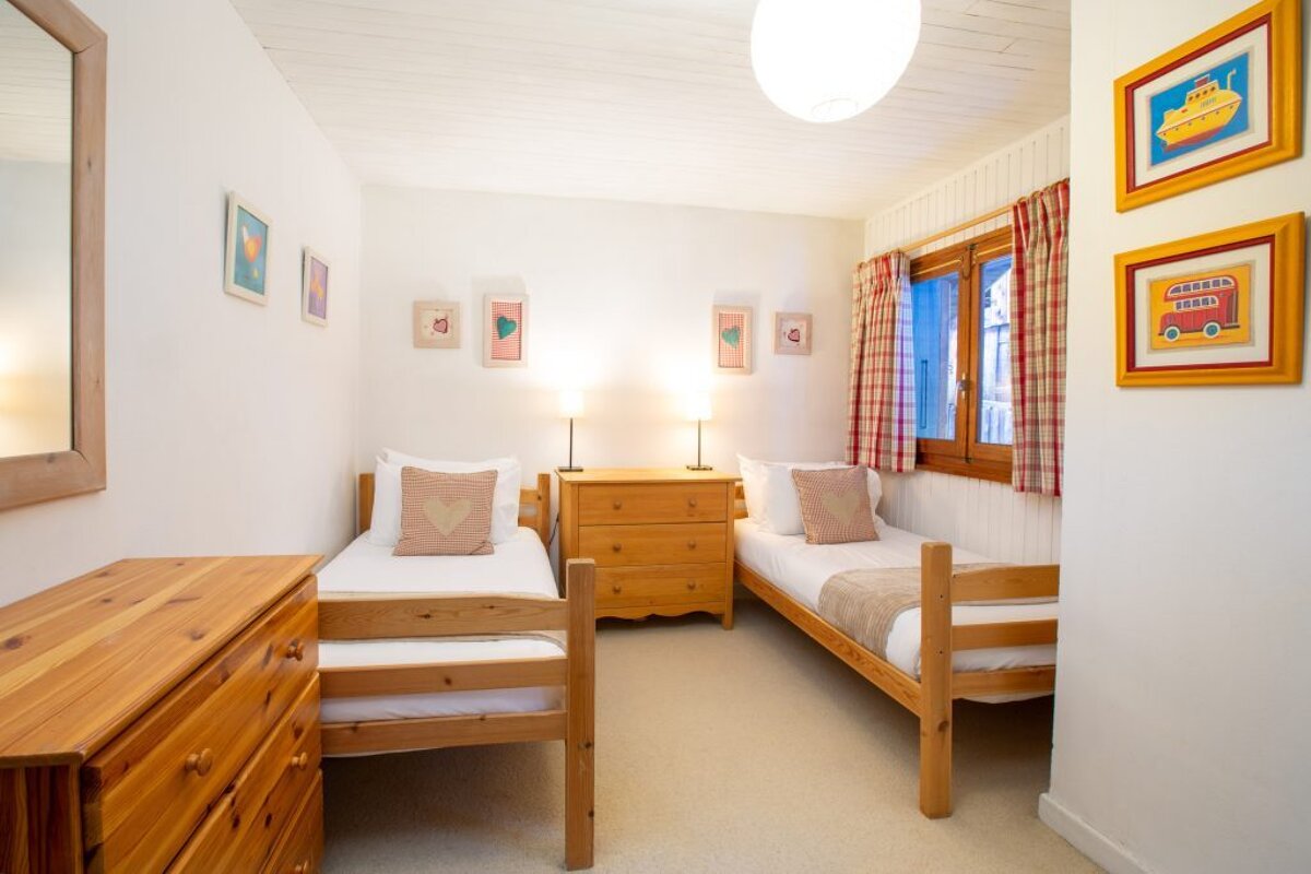 A bedroom with two twin beds and a picture of a school bus on the wall