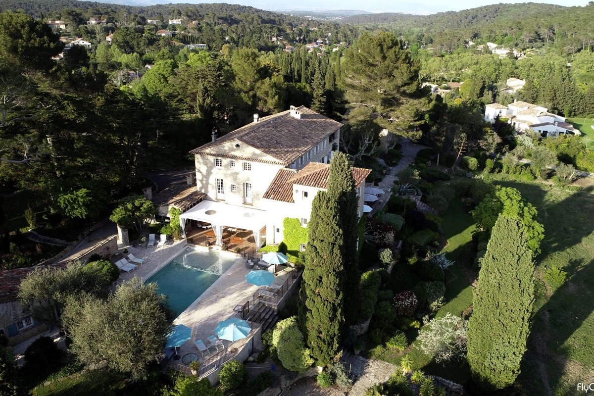 An aerial view of a large house with a swimming pool