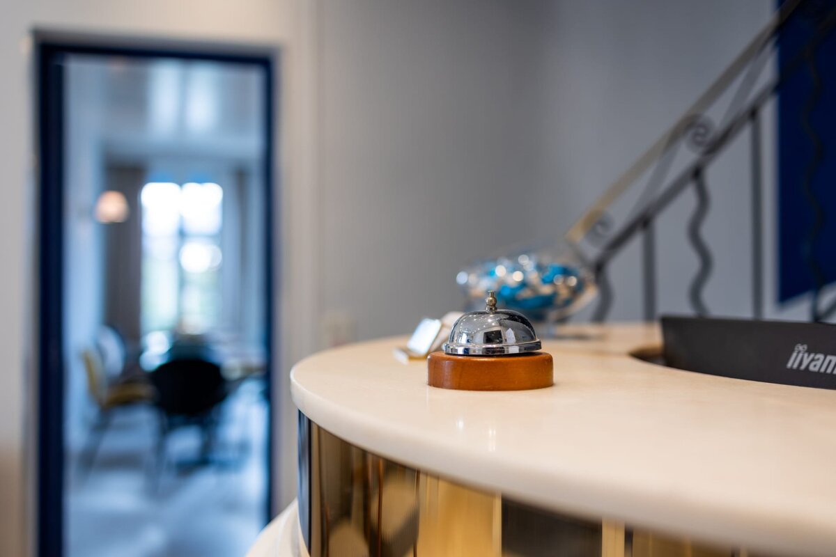 A silver bell sits on a counter in front of a sign that says livan