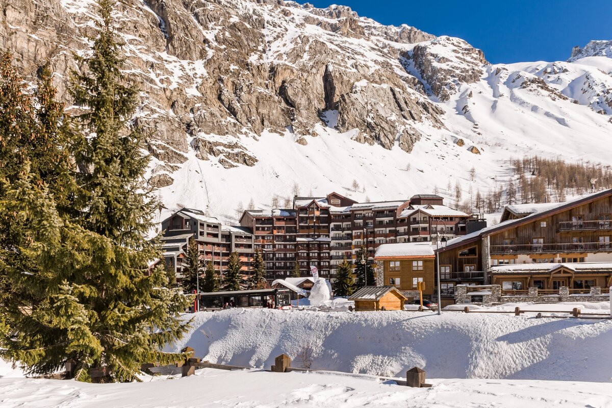 A snowy landscape with a ski resort in the background