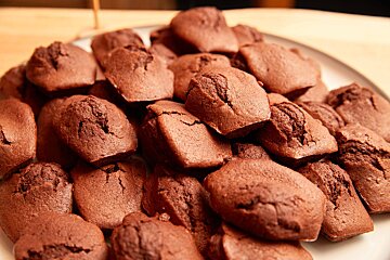 A white plate topped with a pile of chocolate muffins