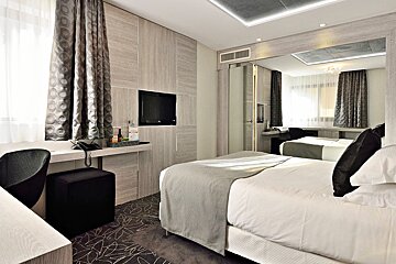 A hotel room with two beds and a flat screen tv