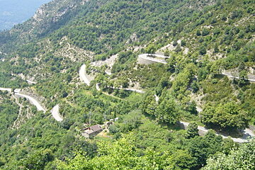 A road winds through a lush green hillside