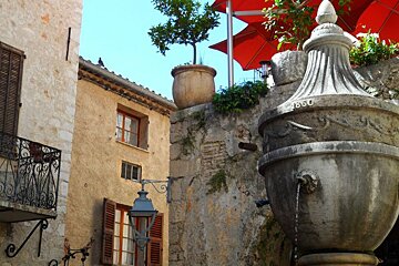 a large stone fountain in a square in Nice