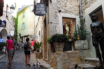 a bronze statue of a woman a cobbled street
