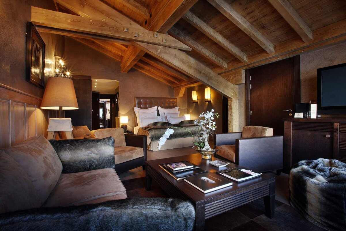 A living room with a couch and chairs and a bed