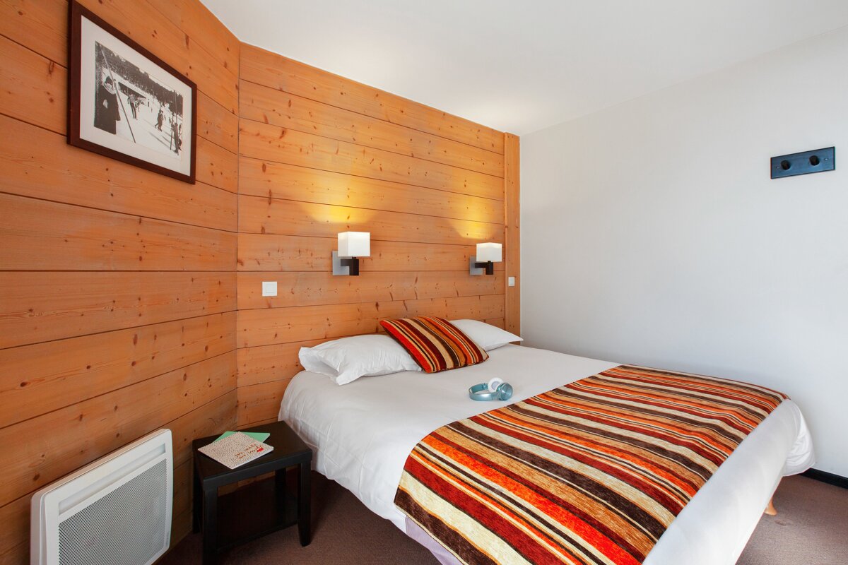 A bedroom with a bed and a picture on the wall