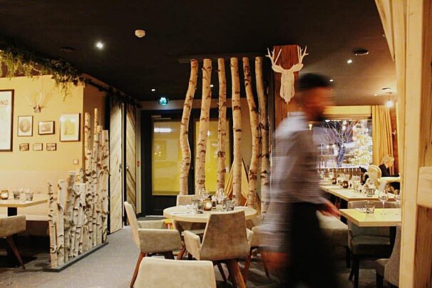 A blurred image of a restaurant with a deer head on the ceiling