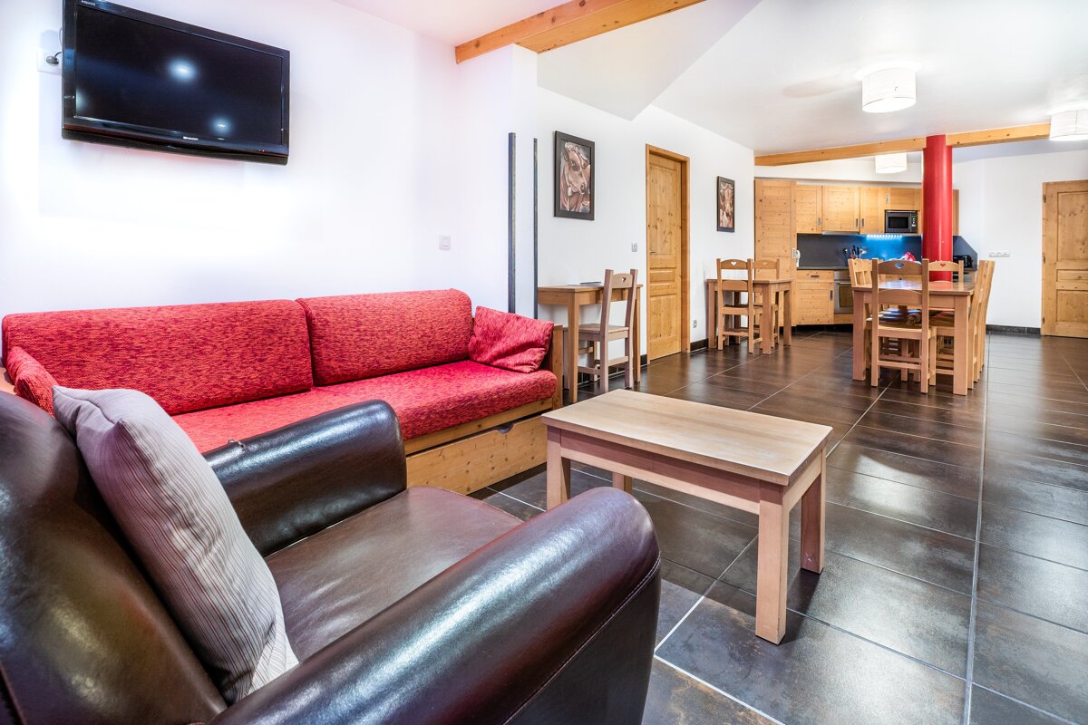 A living room with a red couch and a flat screen tv