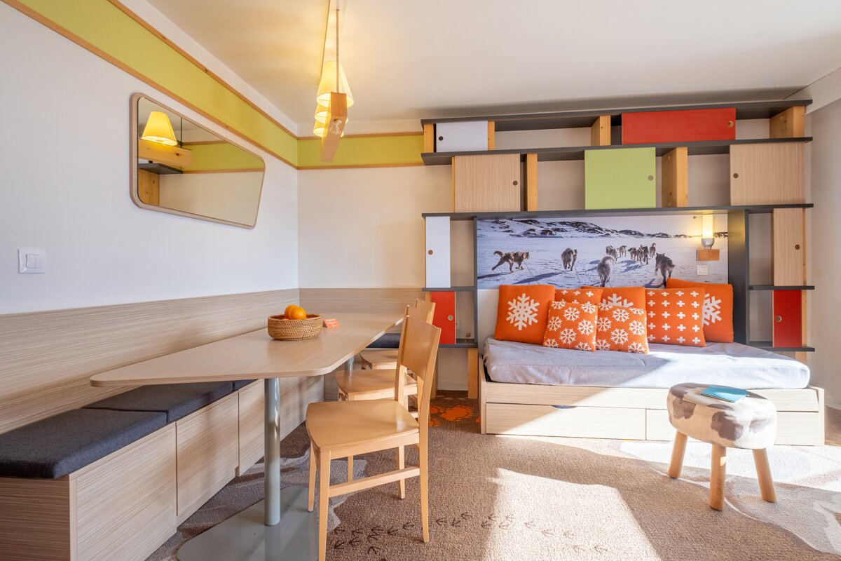 A room with a table and chairs and a painting on the wall