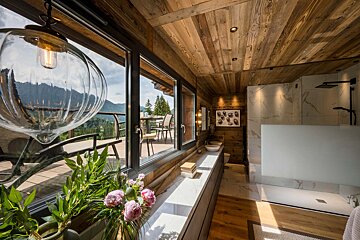 A bathroom with a view of a balcony and mountains