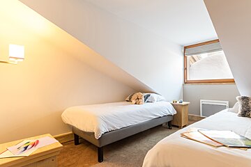 A bedroom with two beds and a window