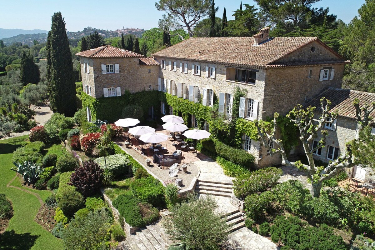 An aerial view of a large stone building with umbrellas in front of it