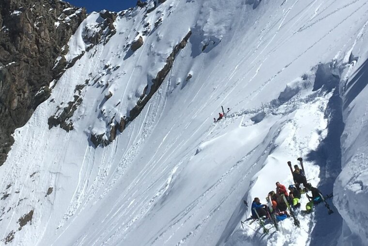 skiers resting on the side of the glacier