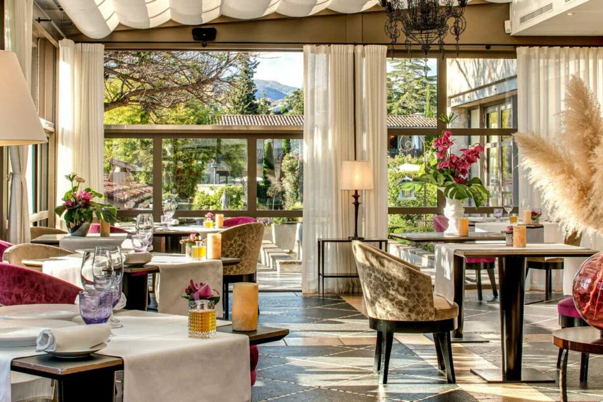 A dining room with tables and chairs and a large window