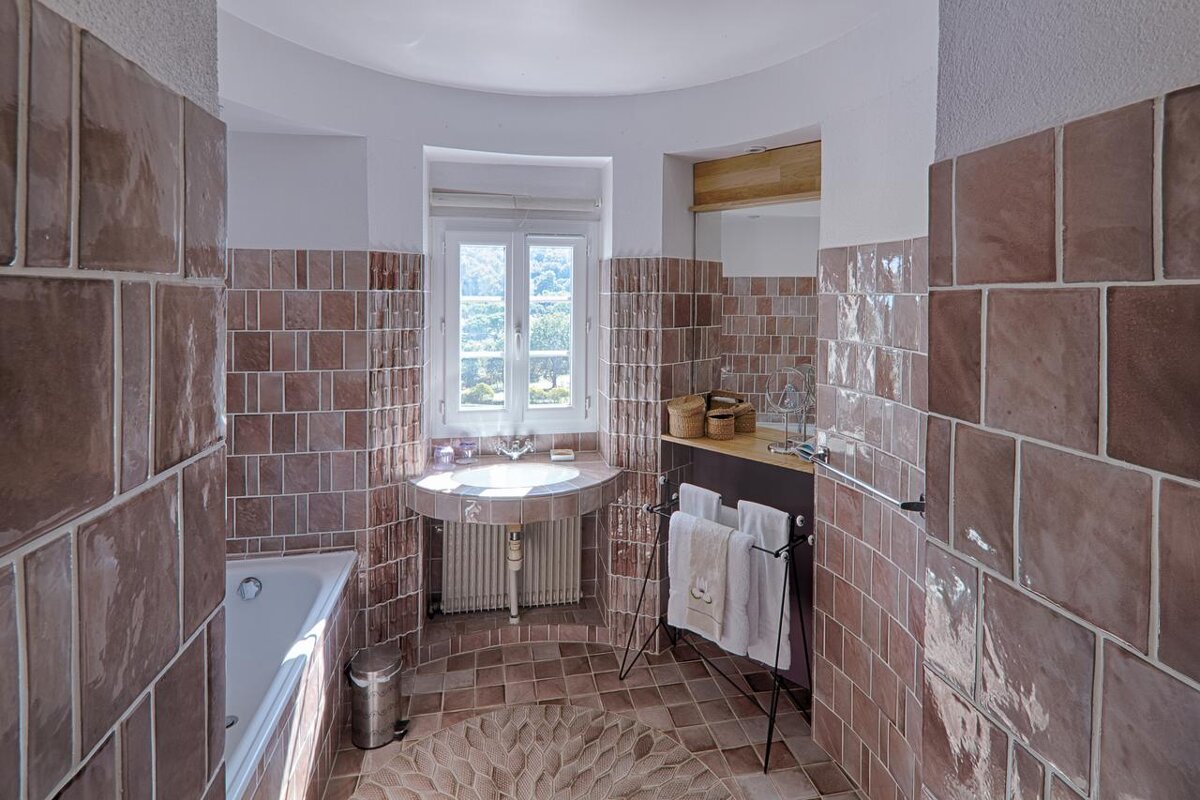 A bathroom with pink tiles and a sink