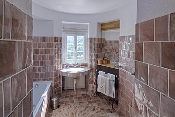 A bathroom with pink tiles and a sink