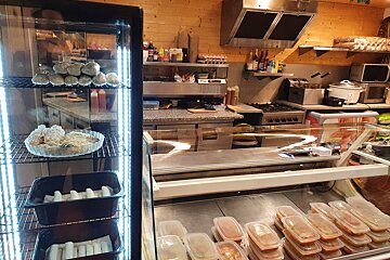 A kitchen with a display case full of food