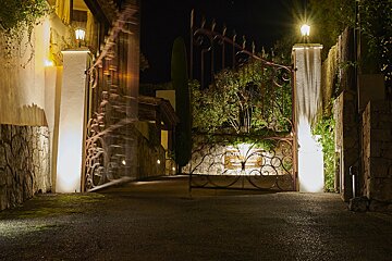 A wrought iron gate is lit up at night