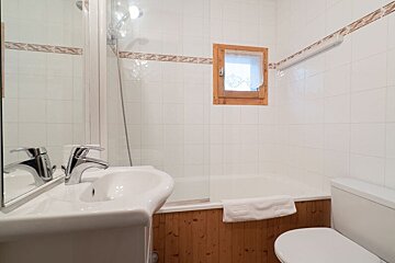 A bathroom with a sink a toilet and a window