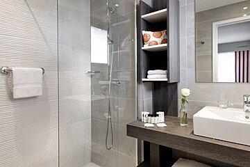 A bathroom with a sink a mirror and a shower