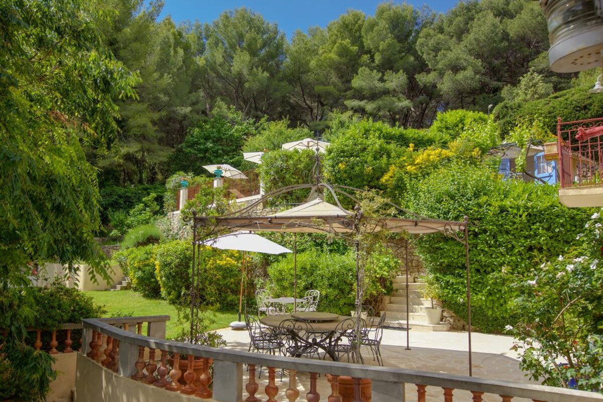 A table and chairs under an umbrella in a garden