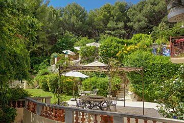 A table and chairs under an umbrella in a garden
