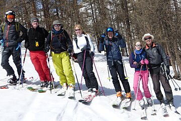 a row of skiers on the edge of a piste