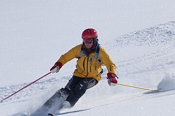 a skier in a yellow jacket