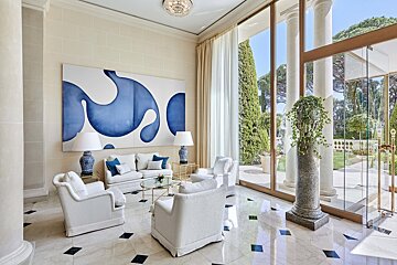A living room with a blue and white painting on the wall