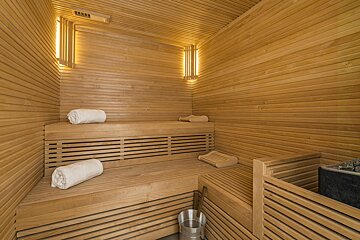 A wooden sauna with white towels on the benches