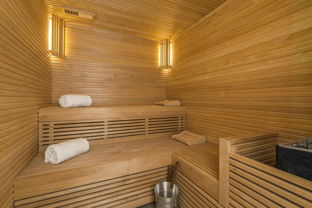 A wooden sauna with white towels on the benches