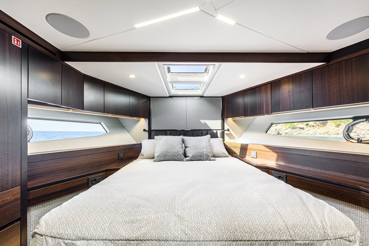 A bedroom on a boat with a sign that says ' emergency exit ' on it