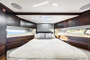 A bedroom on a boat with a sign that says ' emergency exit ' on it