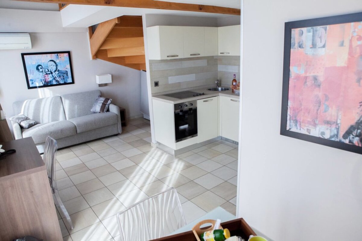 A living room with a couch and a picture of a man and woman on the wall