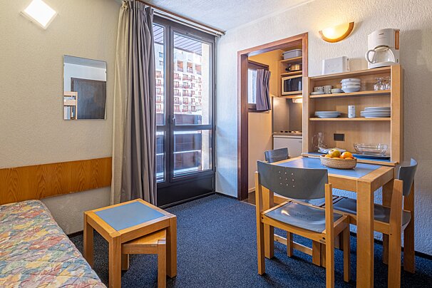 A room with a table and chairs and a coffee maker