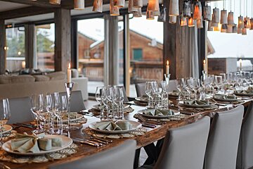 A long dining table with plates and glasses on it