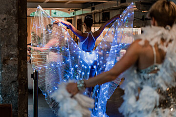 A woman in a white dress with blue lights on her wings