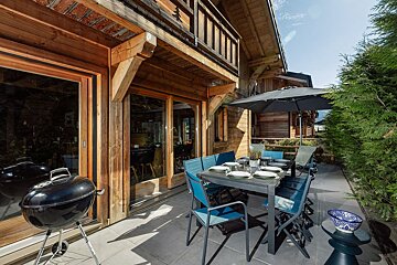 A patio with a table and chairs and an umbrella