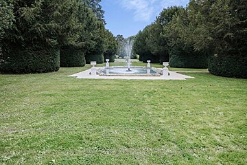 A fountain in the middle of a lush green field