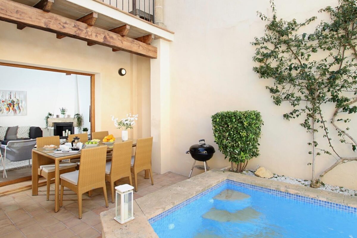 A patio with a table and chairs and a swimming pool