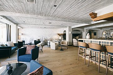 A living room with blue chairs and a bar