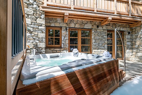 A hot tub outside of a stone building
