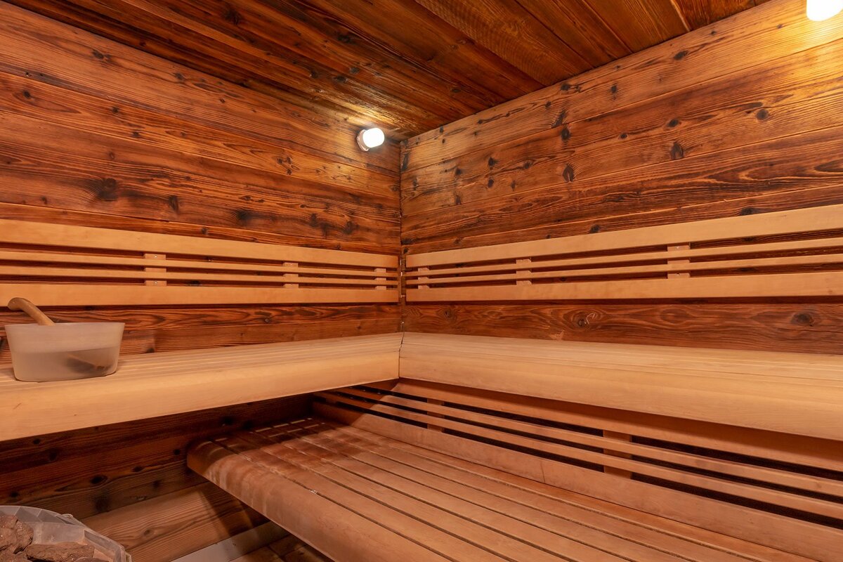 A wooden sauna with a bucket of water on the bench
