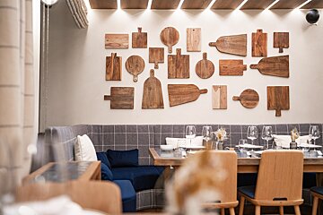 A dining room with wooden cutting boards on the wall