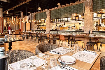 A dining room with tables and chairs and a placemat that says