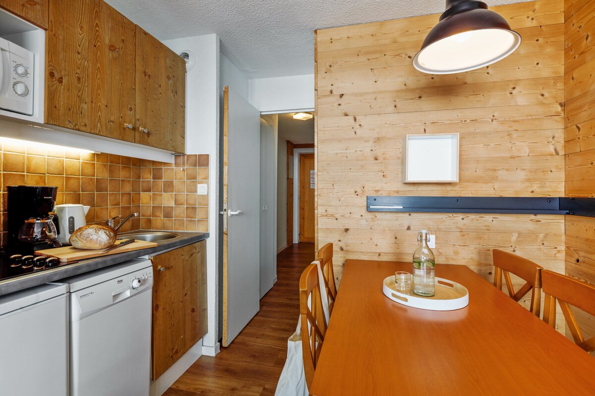 A kitchen with a table and chairs and a bottle of water