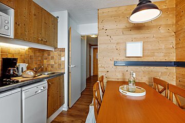 A kitchen with a table and chairs and a bottle of water