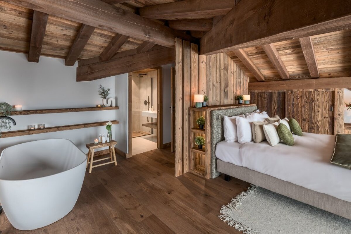 A bedroom with a bathtub and a bed