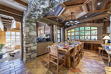 A dining room with a wooden table and chairs